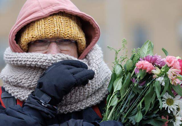 A person holds a bouquet of flowers while awaiting a procession of Buddhist monks at Dorothea Dix Park as a part of the Walk for Peace on Jan. 24 in Raleigh, North Carolina.